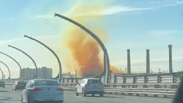 С территории Кировского завода в небо поднимаются клубы оранжевого дыма