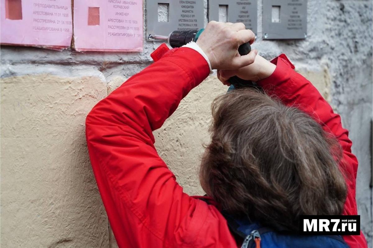 Жительница дома № 21 по Английскому проспекту устанавливает табличку в память о Елене Комендантовой. Фото: Павел Борисенко / MR7