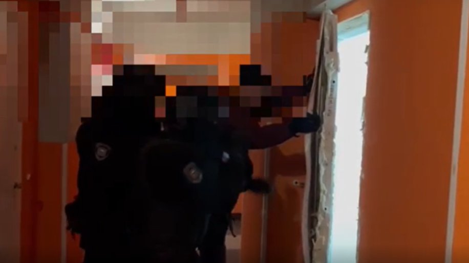Сотрудники полиции ломают дверь в квартиру. Фото: скриншот видео от пресс-службы ГУ МВД по Петербургу