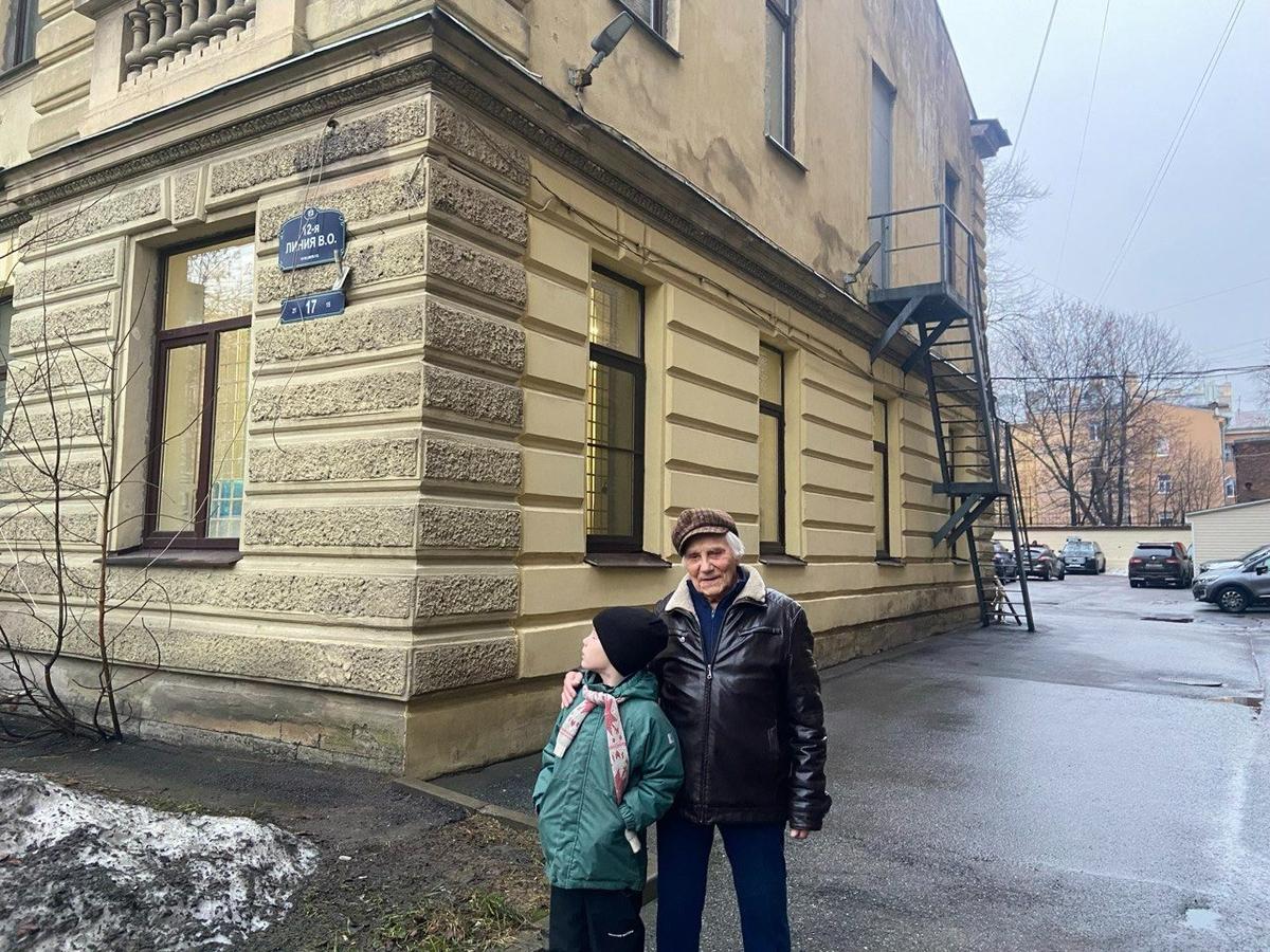 Дмитрий Вячеславович Воронин (муж Анастасии Николаевны) с правнуком Львом у дома на 12-й линии, 17. Там жила семья во время блокады, а позже разместилась подстанция скорой помощи. Фото: Валерия Шимаковская / MR7