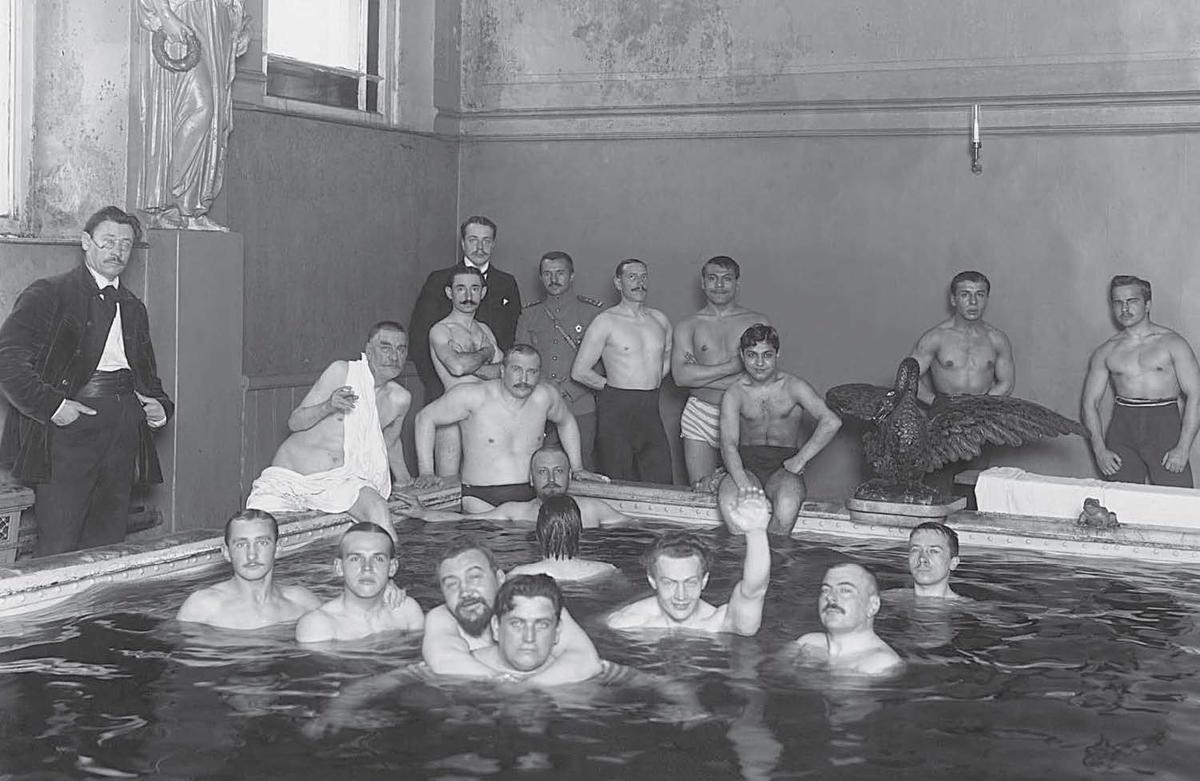 Бассейн в Егоровских банях. Писатель Степан Скиталец (стоит у окна слева); преподаватель французского языка и пловец Леонид Романченко (первый в центре группы в бассейне); писатель Александр Куприн (обнимает Романченко) и другие. Карл Булла. 1913 год. ЦГАКФФД СПб