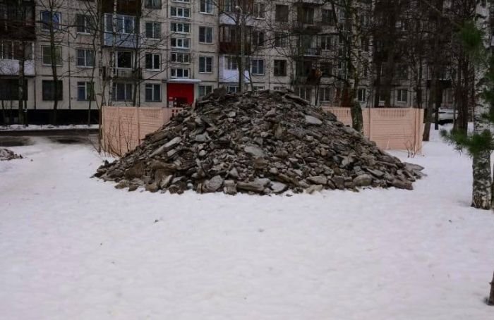 После уборки дворов в Ульянке коммунальщики оставили горы грязного снега на газонах